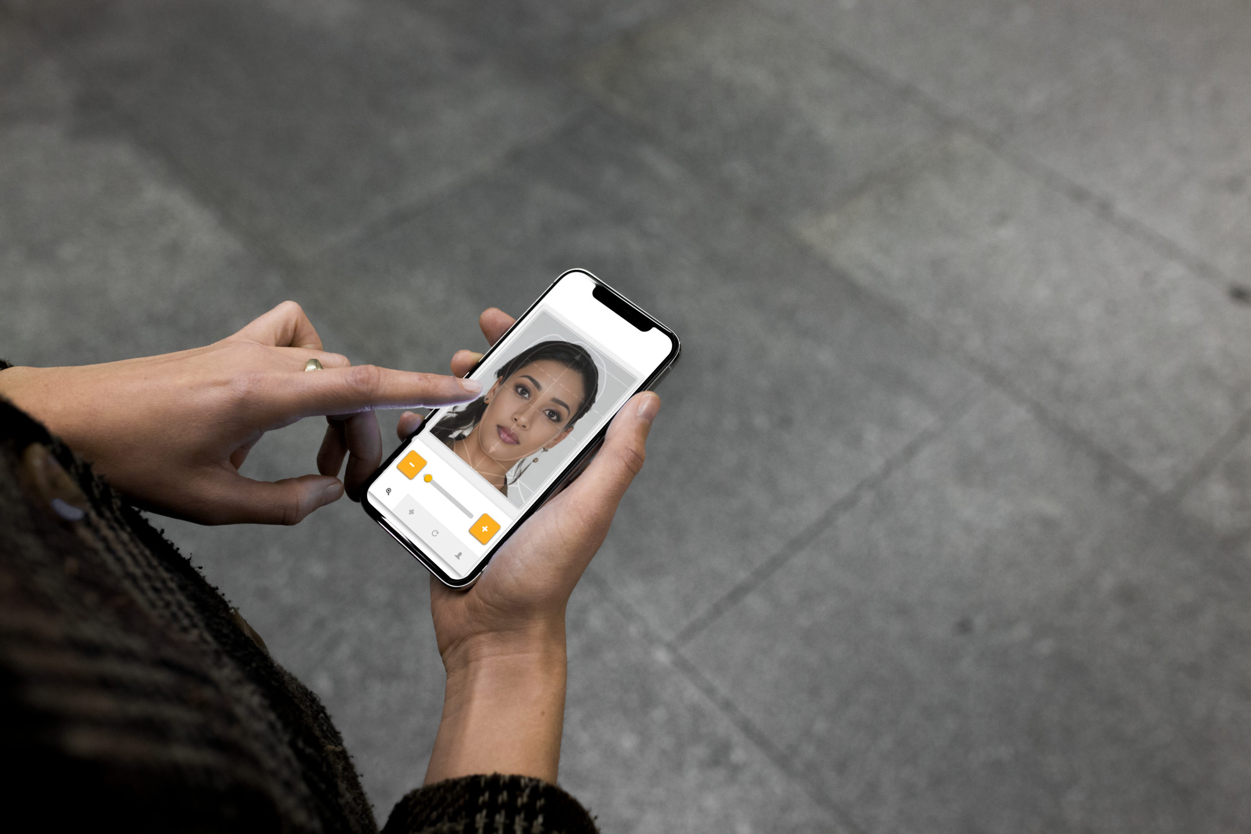 Frau passt ein Foto im Passfoto-Generator auf ihrem Smartphone an biometrische Schablone an.